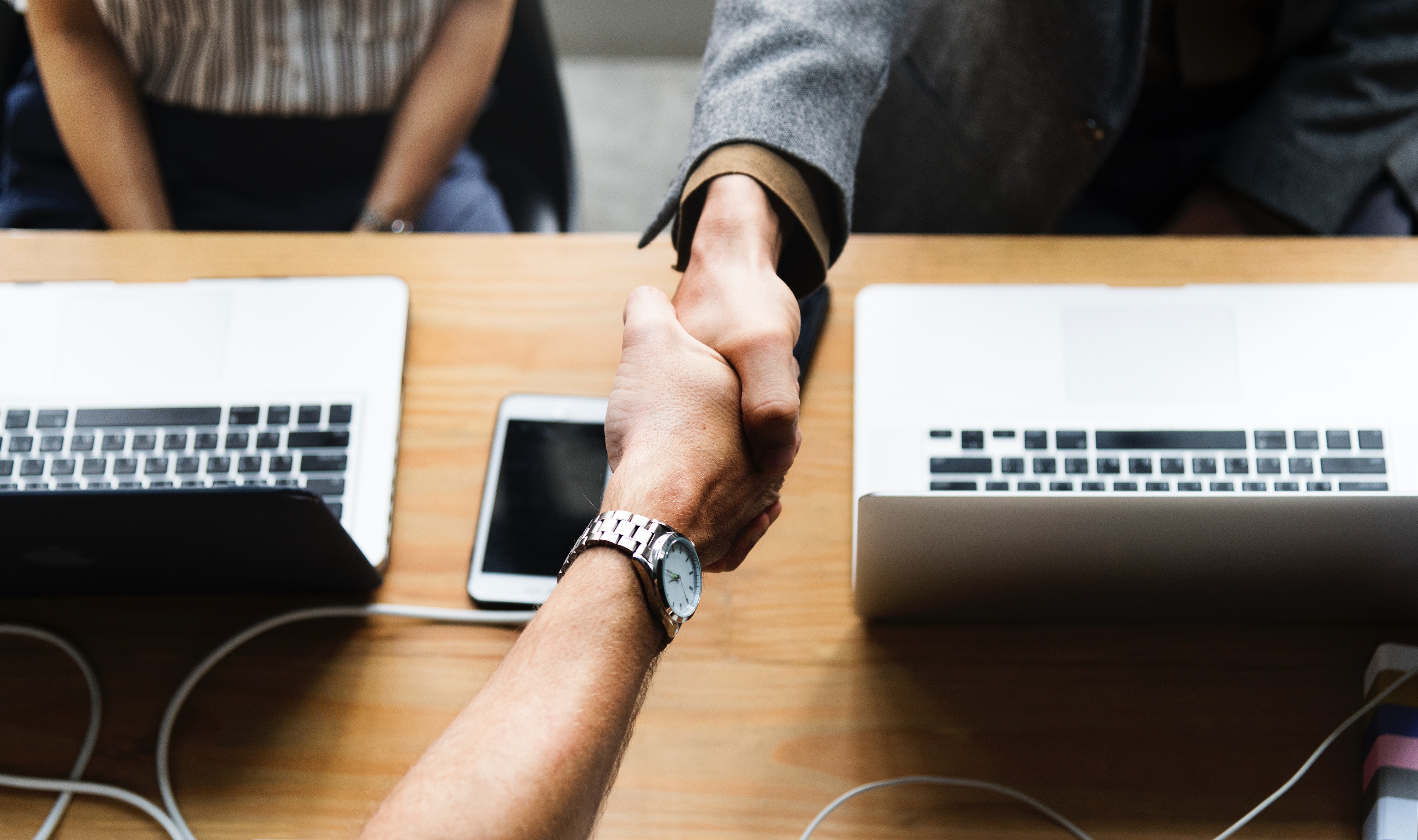 business people shaking hands over a desk