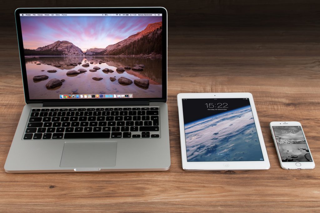 laptop, tablet, and smartphone on a wooden table