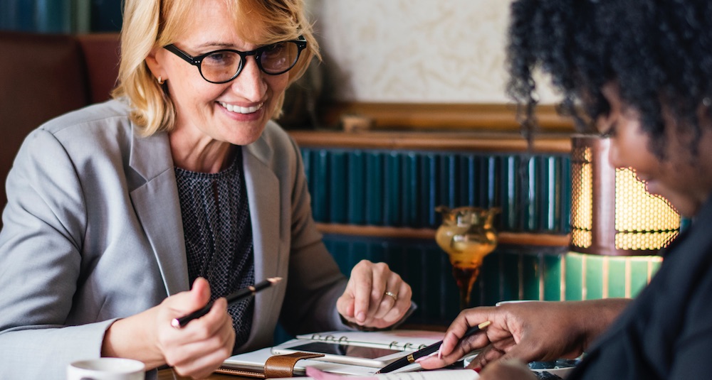 One white woman and one black woman going over a budget plan